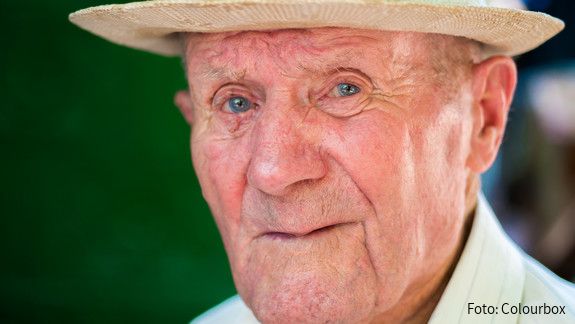 Very old man portrait with emotions. Grandfather happy and smiling. Portrait: aged, elderly senior. Close-up of a pensive old man in white hat sitting alone outdoors at summer.