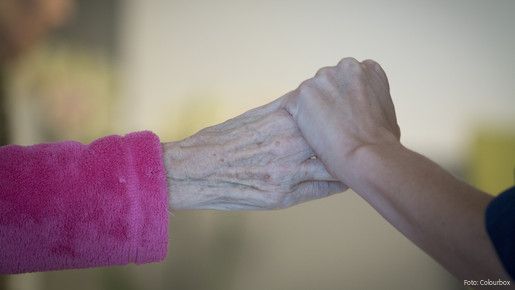 Die Hand eines jungen Menschen hält die Hand eines alten Menschen